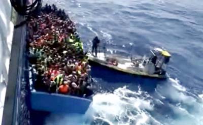 A boat full of migrants is seen next to Swedish ship Poseidon during a rescue operation in the sea off the coast of Libya on Wednesday.