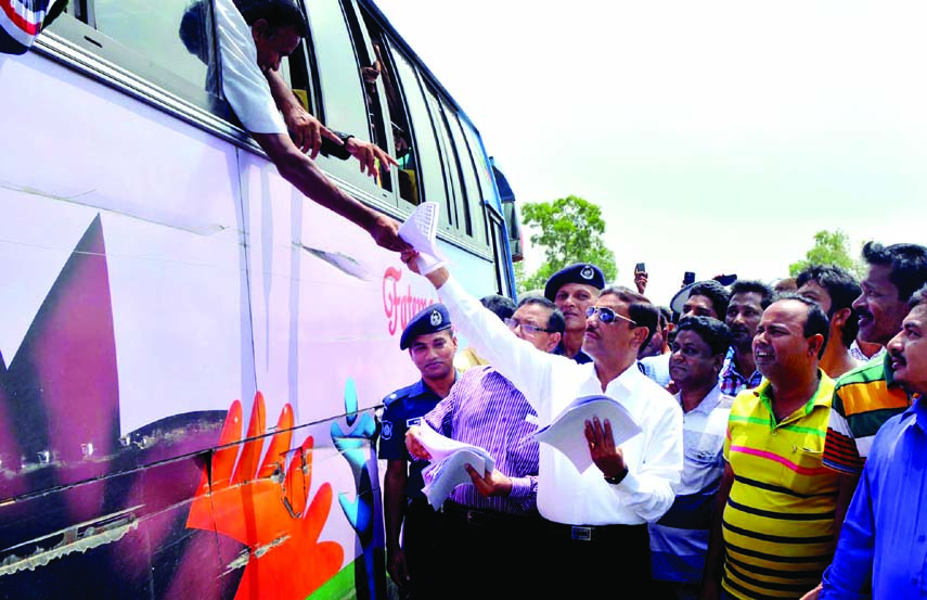 Road Transport and Bridges Minister Obaidul Quader distributing leaflets of awareness among the passengers and drivers on Thursday when he visited construction work of road divider at Pashchimpara Highway of Bangabandhu Bridge.