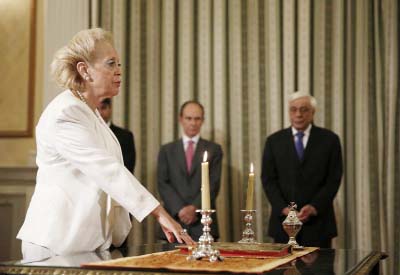 Vassiliki Thanou, 65, take a religious oath during a swearing in ceremony at the Presidential Palace in Athens on Thursday to become Greece's first female prime minister.