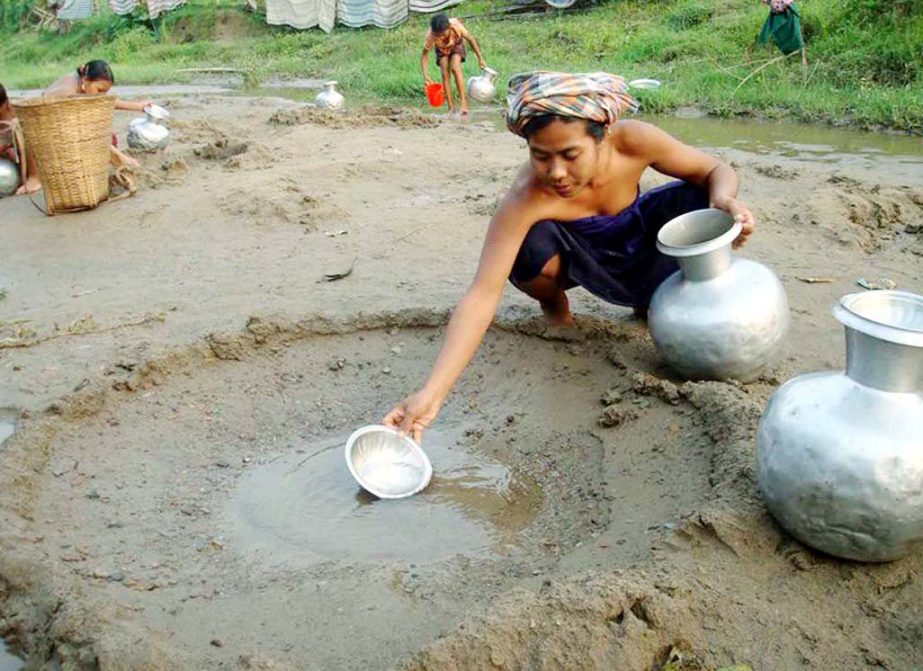 Tribal people are collecting drinking water by making a hole in a canal at Bhikhimghiri Marma Para. This picture was taken on Thursday.