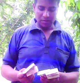 BOGRA: A prison guard is counting money which was allegedly taken from a prisoner's family as bribe at the jail garden recently naming thana clearance. This picture was taken August 26. Photo : Ferdousur Rahman