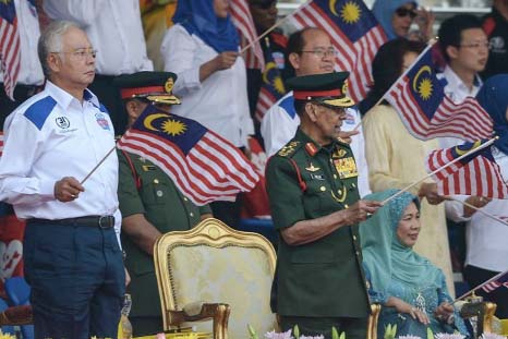 Malaysia's prime minister Najib Razak (L) and Malaysia's King Abdul Halim Mu'adzam Shah (C) wave flags during National Day celebrations.