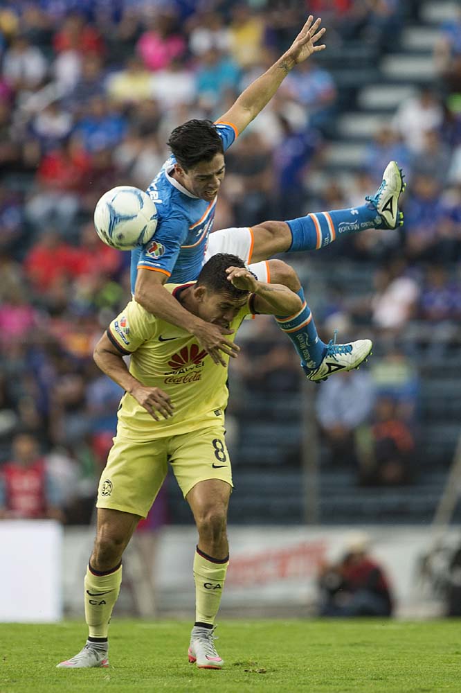 In this photo on Saturday on his way down from jumping for a header, Cruz Azul's Andres Andrade lands on the backside of America's Rubens Sambueza during a Mexican soccer league match in Mexico City.
