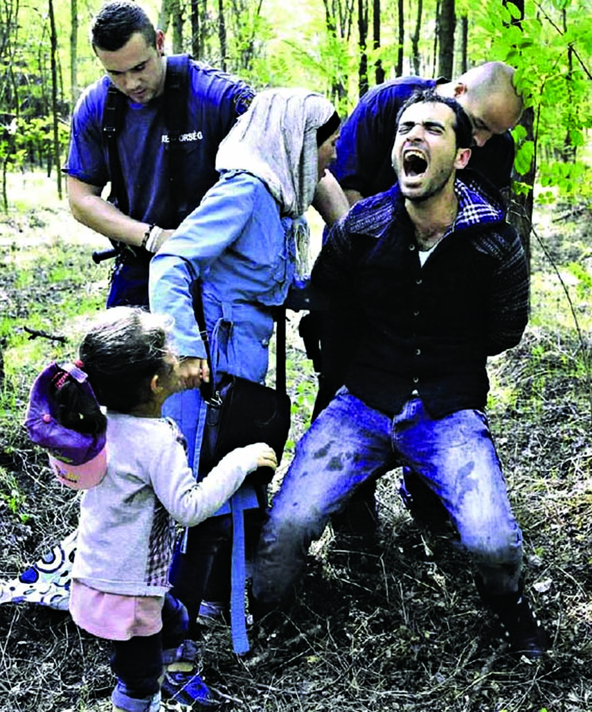 Unceasing tide: Police officers detaining Syrian migrants after they crossed into Hungary.â€“Courtesy: International New York Times