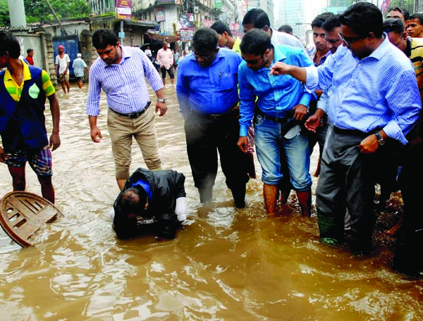 Dhaka South City Corporation Mayor Sayeed Khokon speaking with a section of people of the city's Shantinagar area on Wednesday when he visited the area stagnated by rain water.