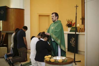 Pastor Gottfried Martens prays with people from Iran during a baptism service in the Trinity Church in Berlin.