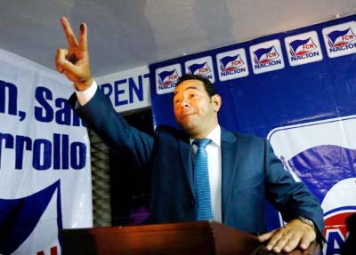 Guatemalan presidential candidate for National Convergence Front, Jimmy Morales, flashes the victory sign as he addresses the media at his campaign headquarters in Guatemala City, on Sunday.