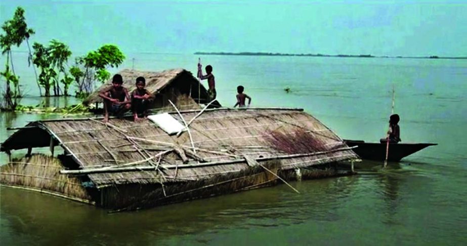 People of Charparbati village under Kurigram Sadar upazila take shelter on roof-top of a house as their houses were inundated by flood water.