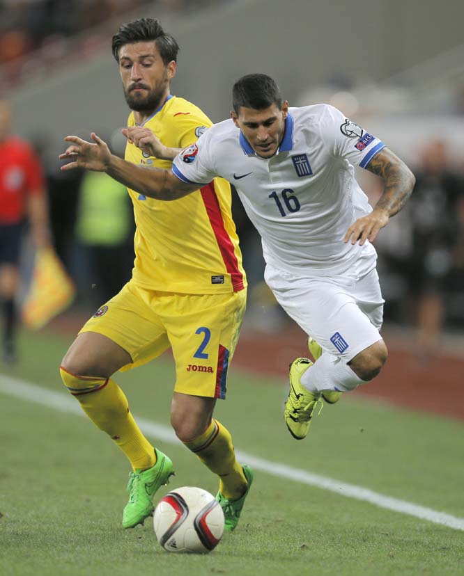 Greece's Nikos Karelis (right) fights for the ball with Romania's Paul Papp during the Euro 2016 group F, qualifying match between Romania and Greece at the National Arena stadium in Bucharest, Romania on Monday.