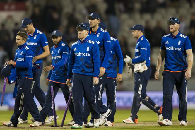 England's Eoin Morgan (centre left) leads his players from the pitch after defeating Australia in the One Day International cricket match between England and Australia at Old Trafford cricket ground in Manchester, England on Tuesday.