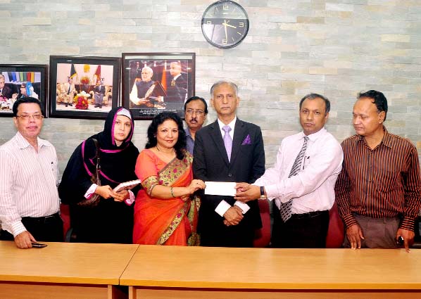 Prof Dr Nashid Kamal, daughter of late Justice Mustafa Kamal hands over a cheque for Tk 5 lakh to DU Treasurer Prof Dr Md. Kamal Uddin on Wednesday at the Vice-Chancellor's office to introduce the gold medal in memory of her father.