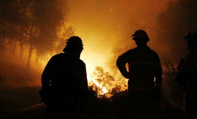 Firefighters watch as the flames of the Butte Fire approach a containment line near San Andreas, Calif. on Friday.
