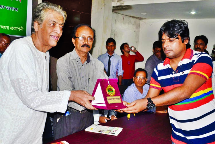 Mahmudul Haque receiving crest from former Secretary Syed Marghub Murshed for his contribution to social activities. The function was organised by Dainik Amader Patrika at the Jatiya Press Club on Sunday.