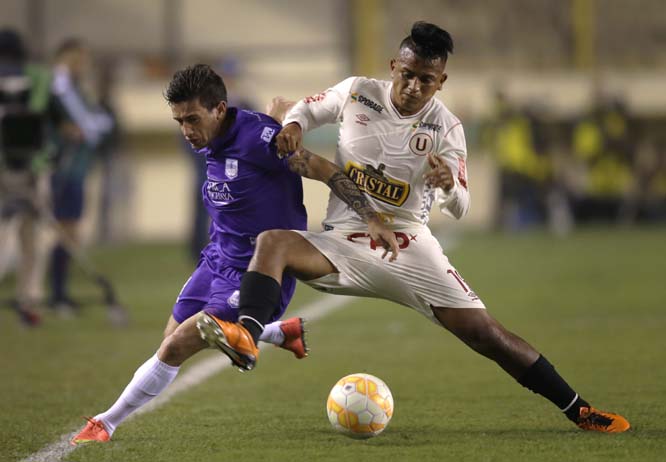 Brian Lozano of Uruguay's Defensor Sporting (left) fights for the ball with Diego Chavez of Peru's Universitario, during a Copa Sudamericana soccer match in Lima, Peru on Tuesday.