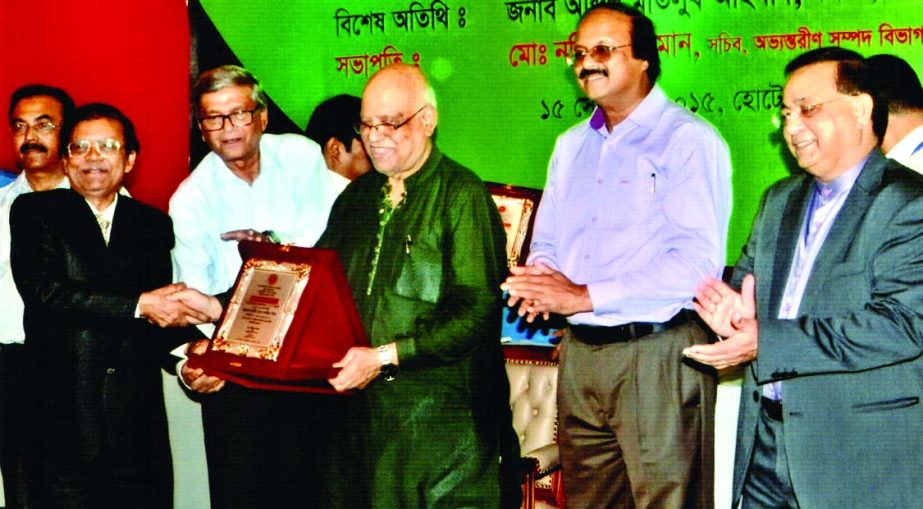 Md Kaus Mia receiving crest from Finance Minister Abul Mal Abdul Muhith as highest tax payer in personal category in the fiscal year 2014-15 at a function organised by the NBR at a city hotel on Tuesday.