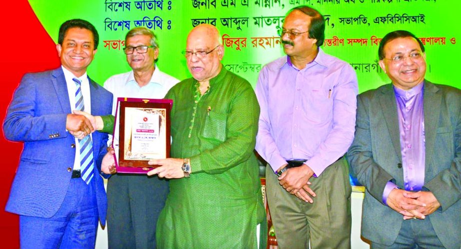 AK Azad, Chairman of Shahjalal Islami Bank Ltd and Managing Director of Ha-Meem Group receiving a crest from Finance Minister AMA Muhith as highest income tax payer in Dhaka City Corporation area for the last tax pay year at a function in the city on Tues