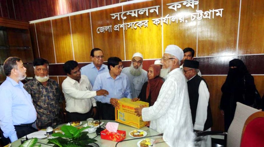 Mesbahuddin, Deputy Commissioner, Chittagong distributing sewing machines among the poor and distressed women for making them self reliant at a meeting of Chittagong Central Eid Jamaat Committee yesterday.