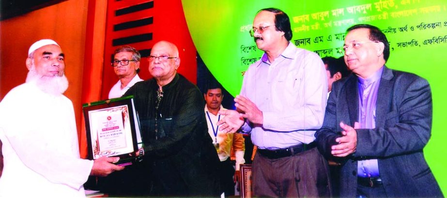 Md Abul Hasem, Managing Director of Hasan Enterprise receiving crest from Finance Minister Abul Mal Abdul Muhith as highest tax payer in district category of Dhaka in the fiscal year 2014-15 at a function organised by the NBR at a city hotel on Tuesday.