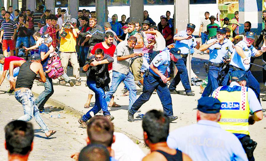 Tensions boiled over as huge groups of migrants waited to board trains at Beli Manastir in Croatia his afternoon. Police are pictured running for cover. Internet photo