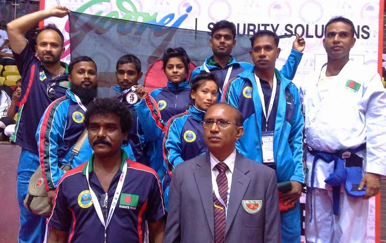The Bangladeshi winners of the 8th Commonwealth Karate Championship with the officials of Bangladesh team pose for a photograph at Talkotara Indoor Stadium in New Delhi, India on Saturday.