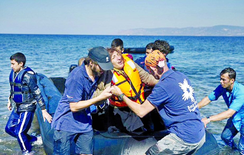 A woman reacts as she arrives aboard a dinghy after crossing from Turkey to the island of Lesbos, Greece.