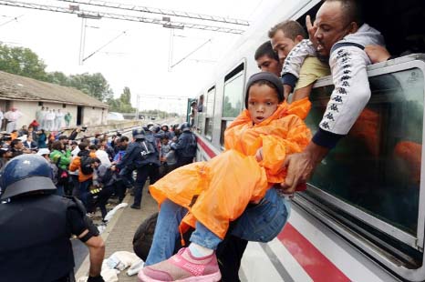 Migrants rush to board a train heading to the Hungarian border near the town of Botovo at the train station in the eastern Croatia town of Tovarnik.