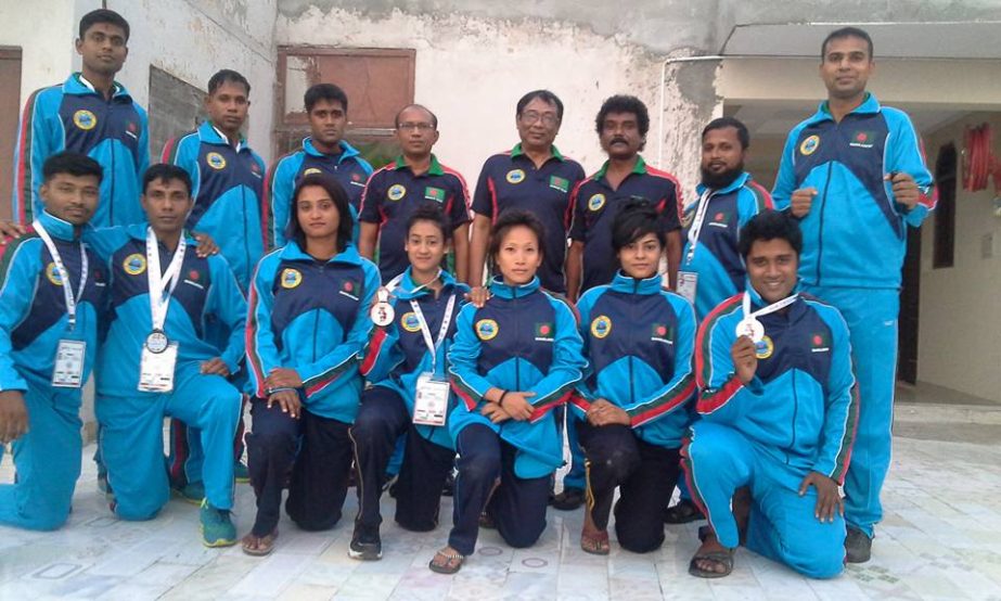 The Bangladeshi winners of the 8th Commonwealth Karate Championship with the officials of Bangladesh team pose for a photograph at Talkotara Indoor Stadium in New Delhi, India on Sunday.