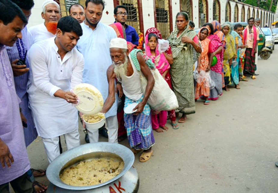 DSCC councilor Hasibur Rahman Manik distributing food among the destitute in the city's Azimpur area on Monday marking 69th birthday of Prime Minister Sheikh Hasina.