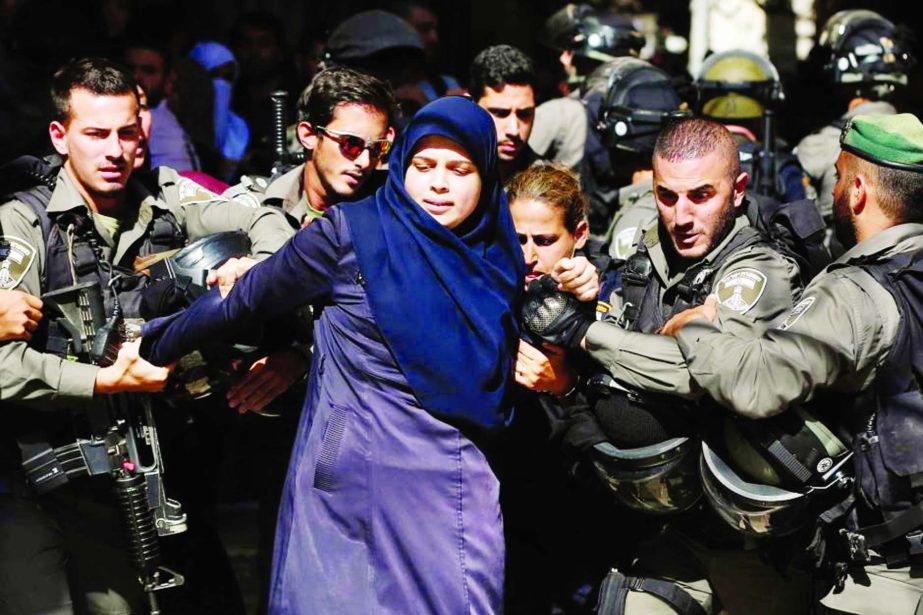 Israeli security forces arrest a Palestinian woman during clashes at al-Aqsa mosque.