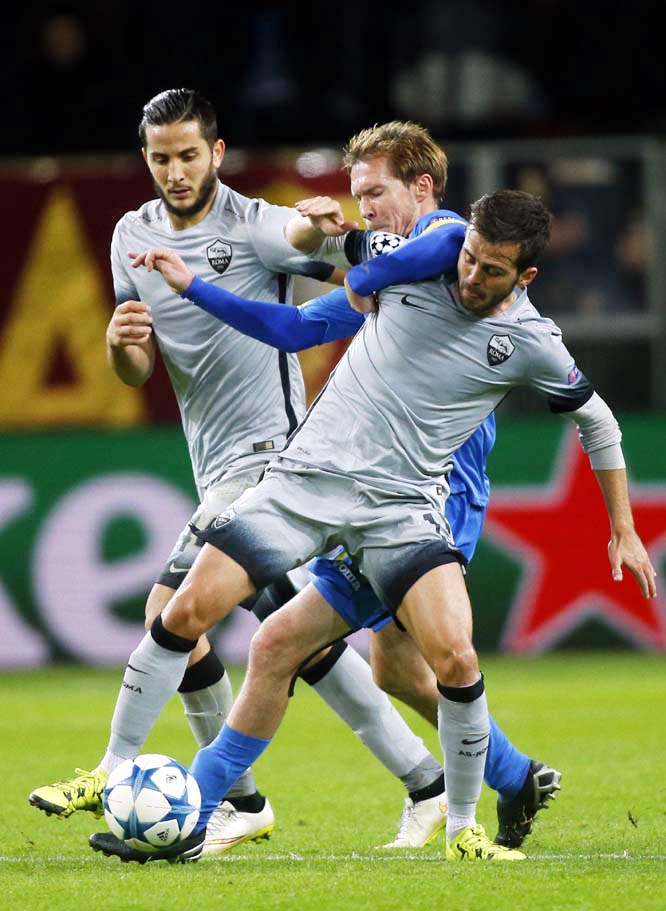 Roma's Miralem Pjanic (right) and BATE's Alexander Hleb vie for the ball as Roma's Kostantinos Manolas (left) looks at them, during the Champions League group E soccer match between BATE Borisov and Roma, in Borisov, Belarus on Tuesday.