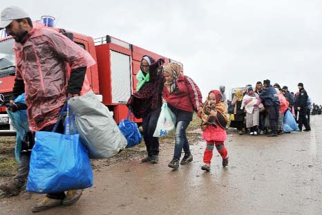 A group of migrants from the Middle East arrive in the rain in the northeastern Croatian village of Bapska, after travelling from neighboring Serbia.