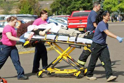 Authorities carry a shooting victim away from the scene after a gunman opened fire at Umpqua Community College in Roseburg, Ore. on Thursday.