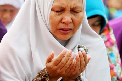 A woman cries during a mass prayer for rain in Palembang, on Sunday.