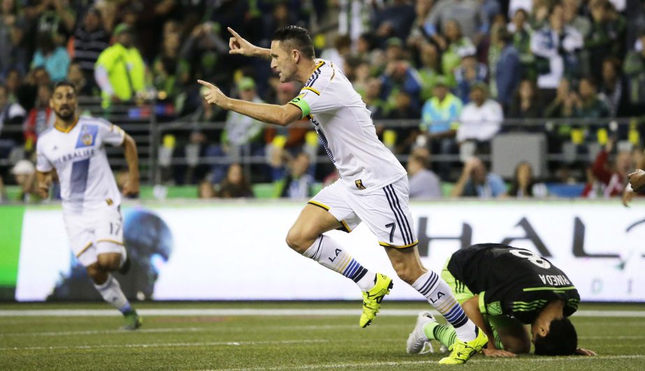 Los Angeles Galaxy forward Robbie Keane (center) celebrates as Seattle Sounders midfielder Gonzalo Pineda kneels on the pitch after Keane scored a goal in the first half of an MLS soccer match in Seattle on Sunday.