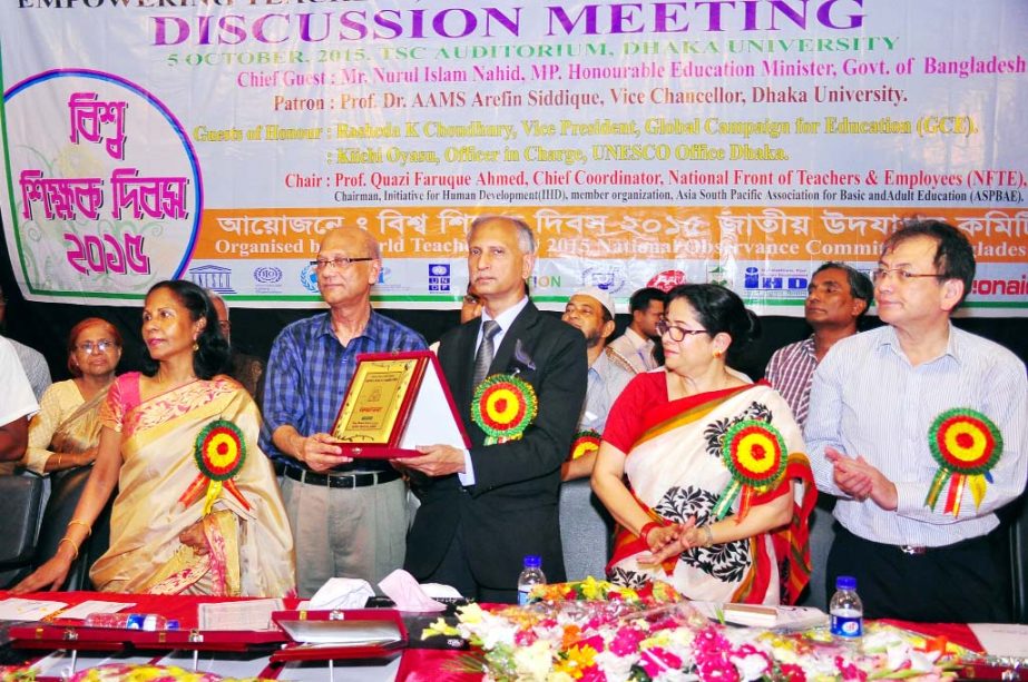 Education Minister Nurul Islam Nahid MP as chief guest hands over "World Teachers' Day Award- 2015"" to the Vice-Chancellor of Dhaka University Prof Dr AAMS Arefin Siddique at a function held Monday at TSC auditorium of the University."