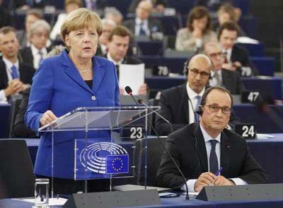 German Chancellor Angela Merkel (L) addresses the European Parliament as French President Francois Hollande (R) listens during a debate on the current situation in the European Union and the way forward on migration and economic policies, in Strasbourg, F