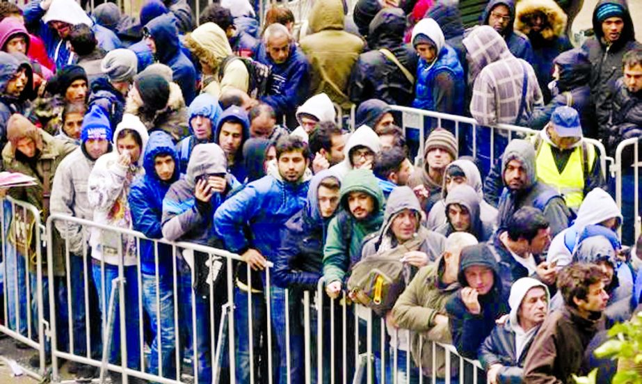 Migrants queue in the compound outside the Berlin Office of Health and Social Affairs (LAGESO) as they wait to register in Berlin, Germany, on Wednesday.