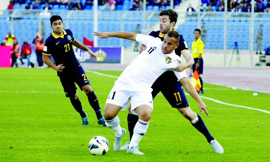 Jordan's Oday Zahran holds off Australia's Tommy Oar during the World Cup Qualifiers between Jordan and Austalia in Amman on Thursday.