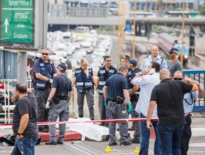 Israeli security forces inspect the body of a Palestinian man who was shot dead after carrying out a stabbing attack on an Israeli soldier and three passers-by in the coastal city of Tel Aviv on Friday.