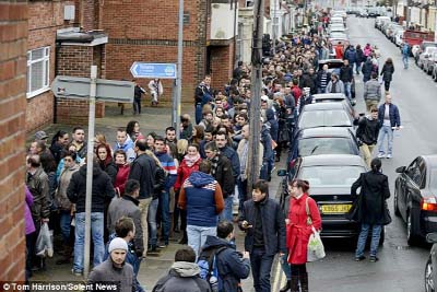 Hundreds of Romanian immigrants line the pavement in Portsmouth.