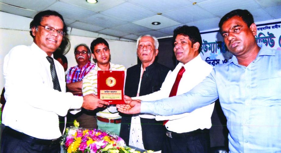 Zahid Hasan, Deputy Manager of Pubali Bank Limited, receiving honorary crest for his contributions to the field of banking from Principal Shahadat Hossain Rana and Advocate Syedul Haq at a discussion on "World Children's Day and Human Rights: Bangladesh