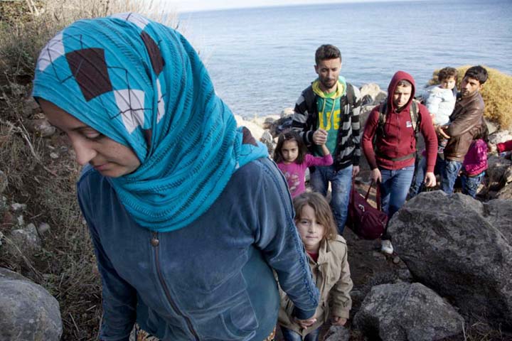 Syrian refugees walk on the rocks after arriving from Turkey onto the shores of the Greek island of Lesbos, in a inflatable dinghy on Monday.