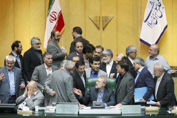 Iran's parliament speaker Ali Larijani, center, speaks with lawmakers in an open session of parliament while discussing a bill on Iran's nuclear deal with world powers, in Tehran, Iran on Sunday