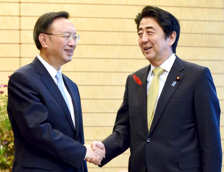 China's State Councillor Yang Jiechi (L) shakes hands with Japan's Prime Minister Shinzo Abe at the start of their talks at Abe's official residence in Tokyo on Wednesday.