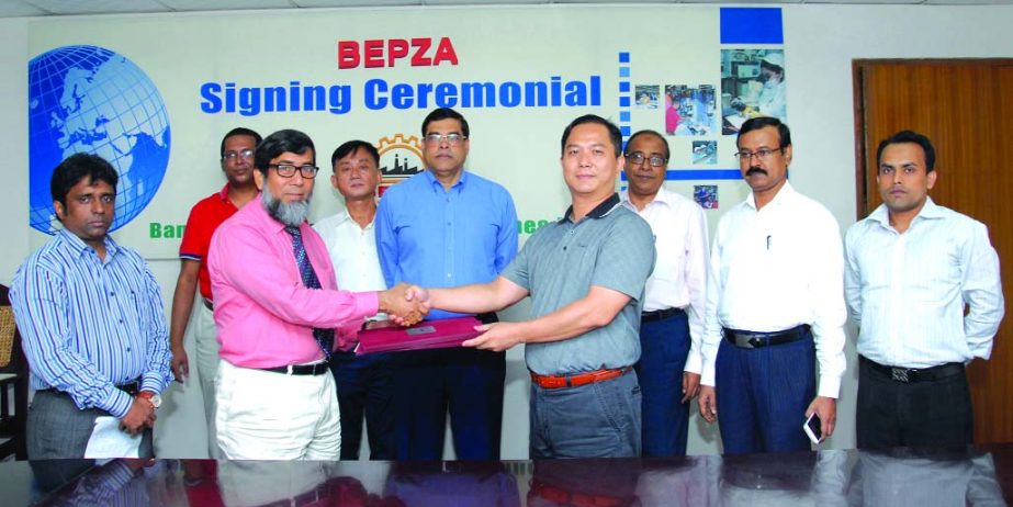 Sayed Nurul Islam, Member (Investment Promotion) of BEPZA and Hung, Chih-Cheng, Managing Director of McEmblem Manufacturing Co. Ltd. signing an agreement at BEPZA Complex in the city on Wednesday for investing $ 6.03 m in Comilla EPZ.