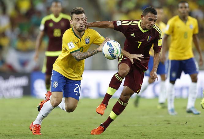 Brazil's Lucas Lima (left) fights for a ball with Venezuela's Arquimedes Figuera during a 2018 World Cup qualifying soccer match in Fortaleza, Brazil on Tuesday.