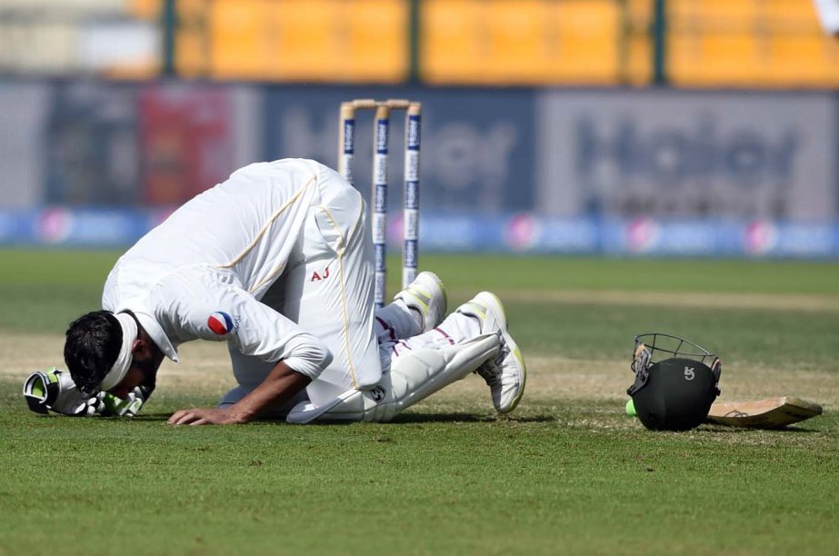 Pakistan batsman Shoaib Malik prays on the ground after completing his 200 runs during the second day of first Test match against England at Zayed Cricket Stadium in Abu Dhabi, United Arab Emirates on Wednesday.