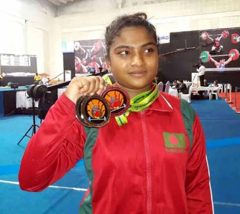 Mabia Akhter Shimanto of Bangladesh showing her medals after earning one gold medal and two silver medals at the Commonwealth Weightlifting Championship at Pune in India on Wednesday.