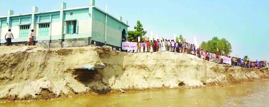 Locals formed a human chain on Wednesday demanding government help to save the educational institution from devouring into river at Chilmari in Kurigram.