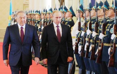 Kazakh President Nursultan Nazarbayev (left) and Russian President Vladimir Putin review an honour guard during a ceremony in Astana on Thursday.